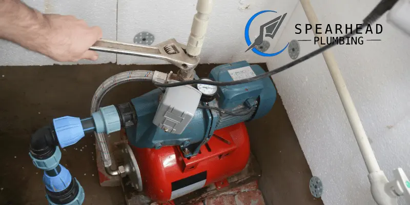 A plumber inspecting a sump pump in the basement of a lakeside home in Lake Saint Louis, MO.