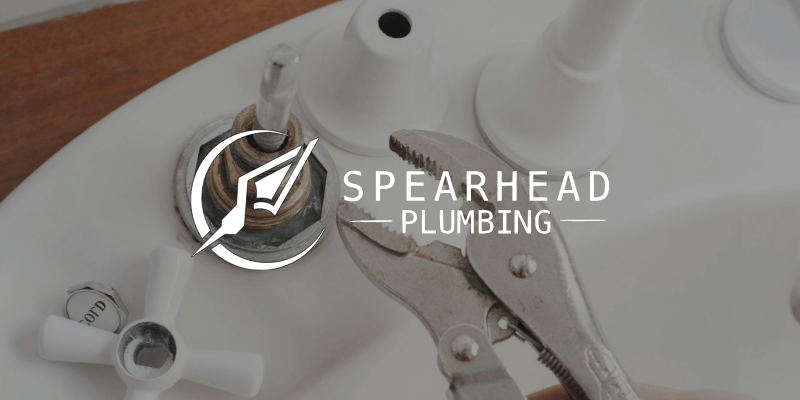 a wrench being used to remove a sink handle